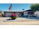 Charming home featuring a well-manicured yard, American flag, and single-car garage at 1710 W 13Th Ave, Apache Junction, AZ 85120