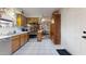 Well-lit kitchen with wooden cabinets, stainless steel appliances, white tiled floors, and an open view into the dining area at 1710 W 13Th Ave, Apache Junction, AZ 85120