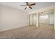 Bedroom features carpet, ceiling fan, and closet with mirrored doors at 222 W Brown Rd # 14, Mesa, AZ 85201