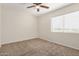 Bedroom with neutral walls, plush carpet, ceiling fan, and bright window at 222 W Brown Rd # 14, Mesa, AZ 85201