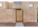 A charming brick-walled entrance with a wooden gate and a glimpse of the building's facade at 222 W Brown Rd # 14, Mesa, AZ 85201