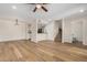 Open-concept living space with wood floors, fan, and staircase access, with open access to the kitchen at 222 W Brown Rd # 14, Mesa, AZ 85201