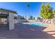 Community pool area with lounge chairs, shade, and fencing around the perimeter at 222 W Brown Rd # 14, Mesa, AZ 85201