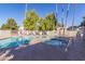 Community pool with surrounding lounge area, palm trees, and blue sky at 222 W Brown Rd # 14, Mesa, AZ 85201