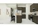 Modern kitchen with stainless steel appliances, dark cabinets, and a central island with bar stools at 25576 N 174Th Dr, Surprise, AZ 85387