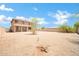 Expansive backyard featuring a covered patio, mature trees, and neutral desert landscaping at 2605 W Darrel Rd, Phoenix, AZ 85041