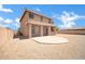 Backyard patio view of a two-story home with neutral desert landscaping and stucco walls at 2605 W Darrel Rd, Phoenix, AZ 85041