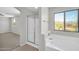 Bright bathroom featuring a walk-in shower, soaking tub, and view from the window at 2605 W Darrel Rd, Phoenix, AZ 85041