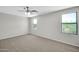 Neutral bedroom offers plenty of natural light with three windows and soft carpeting for comfort at 2605 W Darrel Rd, Phoenix, AZ 85041