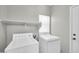 The laundry room features a white washer and dryer, overhead shelving, and a window for natural light at 2605 W Darrel Rd, Phoenix, AZ 85041