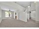 Neutral living room with high ceilings, carpet, ceiling fan, and staircase at 2605 W Darrel Rd, Phoenix, AZ 85041