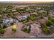 Wide aerial shot of a home with an outdoor pool, sports court, and surrounding neighborhood with lovely sunset at 2661 E Birchwood Pl, Chandler, AZ 85249