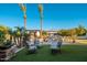 Serene backyard oasis with manicured lawn, mature palm trees, and luxurious seating around the pool area at 2661 E Birchwood Pl, Chandler, AZ 85249