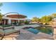 Expansive backyard featuring a pool, covered patio, and lush landscaping, perfect for outdoor entertaining at 2661 E Birchwood Pl, Chandler, AZ 85249