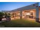 Expansive backyard featuring a covered patio with a built-in grill, lush green grass, and mature palm trees at 2661 E Birchwood Pl, Chandler, AZ 85249