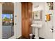 Charming powder room with pedestal sink, decorative mirror, convenient storage and patio access at 2661 E Birchwood Pl, Chandler, AZ 85249