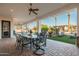 Inviting covered patio featuring brick flooring, ceiling fans, and wrought iron table with lush backyard views at 2661 E Birchwood Pl, Chandler, AZ 85249