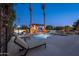 Inviting outdoor pool area with a pergola, waterfall features, and lounge chairs surrounded by tall palm trees at 2661 E Birchwood Pl, Chandler, AZ 85249