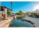 Beautiful pool with waterfall feature, covered patio, and lush landscaping at 2661 E Birchwood Pl, Chandler, AZ 85249