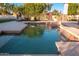 Tranquil pool with custom waterfall feature surrounded by lush greenery and comfortable lounge seating at 2661 E Birchwood Pl, Chandler, AZ 85249