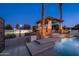 Beautiful backyard featuring a pool with waterfall features, an outdoor kitchen, and mature landscaping at 2661 E Birchwood Pl, Chandler, AZ 85249