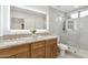 Elegant bathroom featuring double sinks, natural stone counters, and a glass-enclosed shower at 2949 N 29Th St, Phoenix, AZ 85016