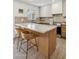 Well-lit kitchen island with wicker bar stools, stainless steel appliances, and modern fixtures at 2949 N 29Th St, Phoenix, AZ 85016