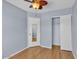 A bedroom with wood floors, a ceiling fan, closet with sliding doors, and a door with a mirror at 2954 N Oregon St # 6, Chandler, AZ 85225