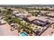 The aerial view showcases a yard complete with lawn, desert landscaping, palm trees, and a sparkling pool at 3022 E Santa Fe Ln, Gilbert, AZ 85297