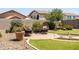 Backyard featuring a circular patio with chairs, lush landscaping, and artificial grass at 3022 E Santa Fe Ln, Gilbert, AZ 85297