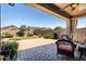 An outdoor seating area with a ceiling fan overlooks a patio, lawn, and landscaped backyard at 3022 E Santa Fe Ln, Gilbert, AZ 85297