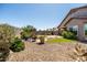 Landscaped backyard featuring a circular patio with seating, xeriscaping, and artificial grass at 3022 E Santa Fe Ln, Gilbert, AZ 85297