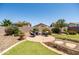 Well-maintained backyard with a circular patio, lush artificial grass, and garden lighting at 3022 E Santa Fe Ln, Gilbert, AZ 85297