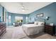Spacious bedroom boasting plush carpeting, blue walls, and a comfortable seating area at 3022 E Santa Fe Ln, Gilbert, AZ 85297