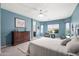 Bright bedroom filled with natural light, featuring an airy design, neutral carpet, and blue walls at 3022 E Santa Fe Ln, Gilbert, AZ 85297