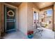Inviting covered front porch with decorative wreath on the front door, chairs, and potted flowers at 3022 E Santa Fe Ln, Gilbert, AZ 85297