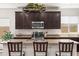 Modern kitchen with dark wood cabinets, stainless steel appliances, and a breakfast bar with seating at 3022 E Santa Fe Ln, Gilbert, AZ 85297
