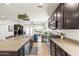 Open concept kitchen with granite countertops, dark cabinetry, and seamless transition to the living area at 3022 E Santa Fe Ln, Gilbert, AZ 85297