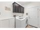 Efficient laundry room with modern appliances, overhead cabinets, and a playful sign at 3022 E Santa Fe Ln, Gilbert, AZ 85297