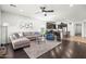 Open-concept living room flows to kitchen; light gray walls, hardwood floors, and modern furnishings at 3022 E Santa Fe Ln, Gilbert, AZ 85297