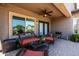 Relaxing covered patio features brick pavers, comfortable seating, and a ceiling fan at 3022 E Santa Fe Ln, Gilbert, AZ 85297