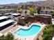 Aerial shot of the community pool, lounge area, and nearby parking in a desert setting at 3434 E Baseline Rd # 126, Phoenix, AZ 85042