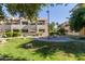 Well-manicured community space offering lush green lawn, picnic table, BBQ grills, and mature landscaping at 3434 E Baseline Rd # 126, Phoenix, AZ 85042