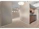 A carpeted hallway leads to a kitchen and living space with natural light at 3434 E Baseline Rd # 126, Phoenix, AZ 85042