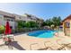 Community pool area with comfortable lounge chairs, tables, umbrellas and mature trees at 3434 E Baseline Rd # 126, Phoenix, AZ 85042