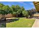 Expansive backyard featuring mature trees, a well-maintained lawn, and a covered patio area at 3537 W Shangri La Rd, Phoenix, AZ 85029
