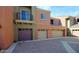 Exterior of townhomes featuring a paved parking area and attached garages at 3935 E Rough Rider Rd # 1101, Phoenix, AZ 85050