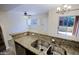 Stylish kitchen with granite countertop bar, double sink, and view into the living area at 3935 E Rough Rider Rd # 1101, Phoenix, AZ 85050