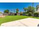 Lush green backyard featuring a patio, grass area, and mature trees at 3940 E Heather Ct, Gilbert, AZ 85234