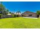 Expansive backyard featuring lush green grass, privacy wall, and mature trees, perfect for outdoor enjoyment at 3940 E Heather Ct, Gilbert, AZ 85234